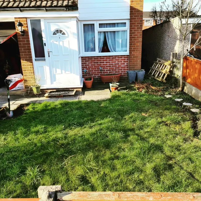 Small back garden lawn before the work, worn and patchy outside a back door