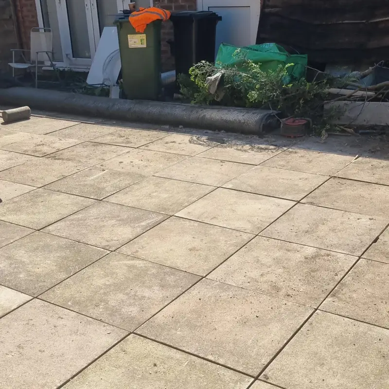 New buff paving slabs laid outside the back of the house in the cleared garden